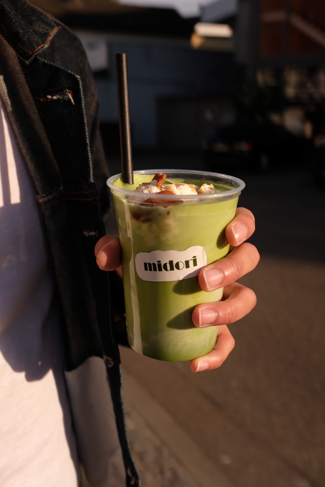 Matcha Drink in der Hand vor dem midori café